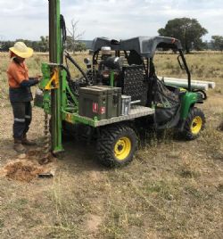 Soil auger sampling in progress.