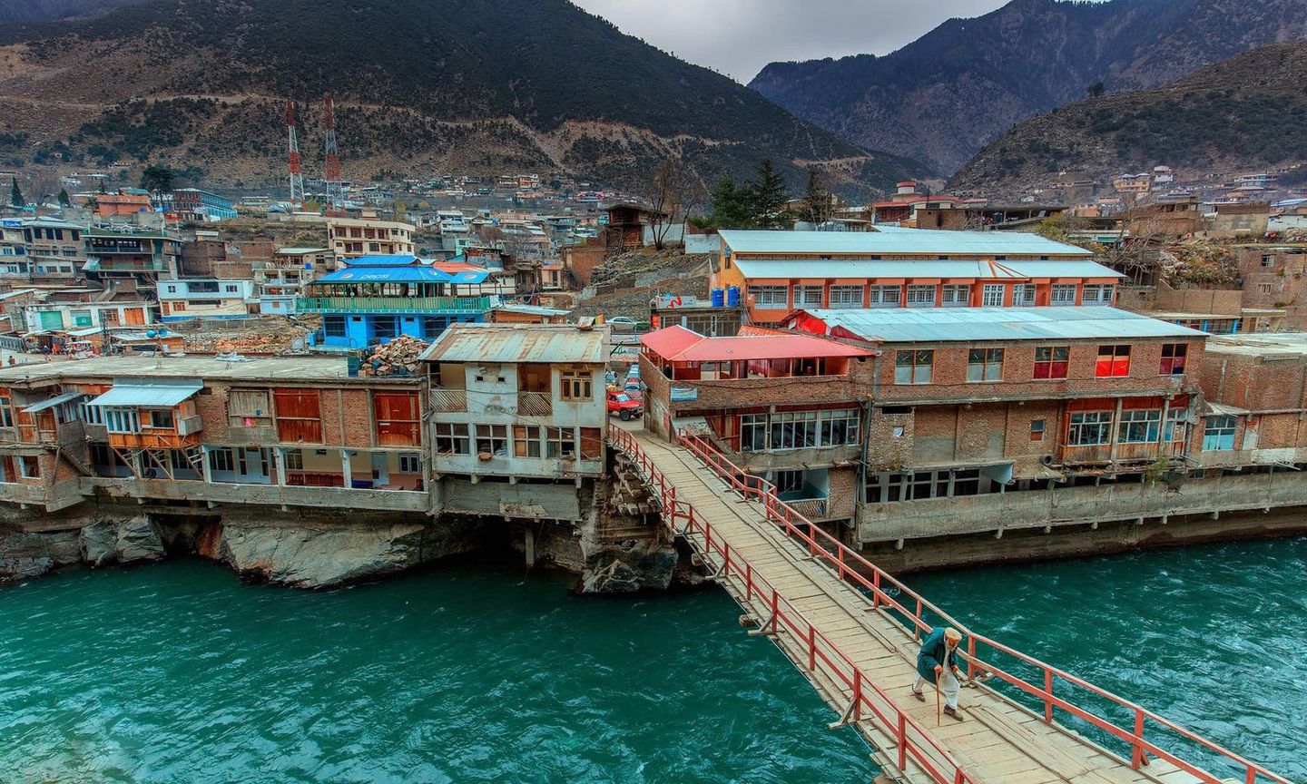 A footbridge over the Swat River to Bahrain’s riverside buildings