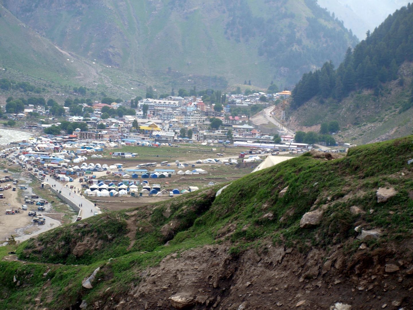Naran town and its campsites on the valley floor, seen from a grassy slope