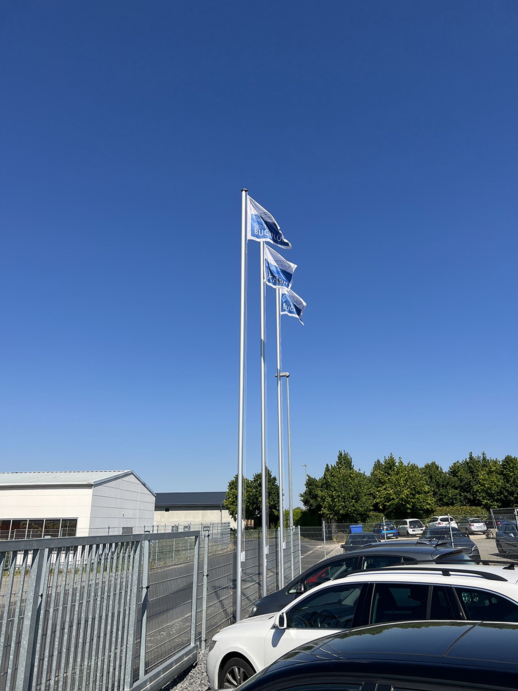 The company is expanding and raises its flags in Bruchhausen in front of their new office.