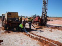 Sampling brine from air core drill hole.