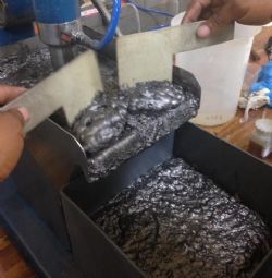 Figure 2. Flotation chamber at Mintek showing the manual recovering the graphite flake concentrate