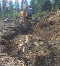 Excavator removing shallow alluvium cover from new pegmatite exposures located just south of the North Aubry prospect.