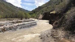 Snowmelt water scouring river crossing track along the Chanach River.
