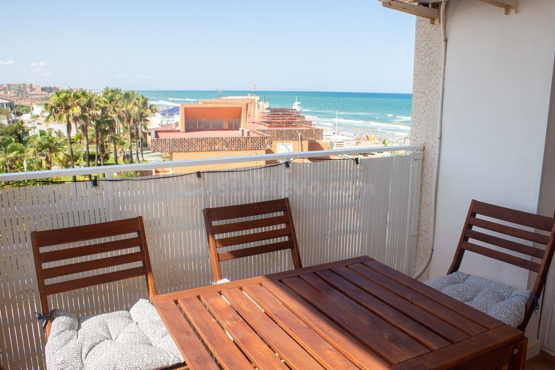 Exclusivo apartamento en primera línea de playa con 2 dormitorios, 1 baño, balcón con vistas al mar y gran piscina comunitaria con jardín.