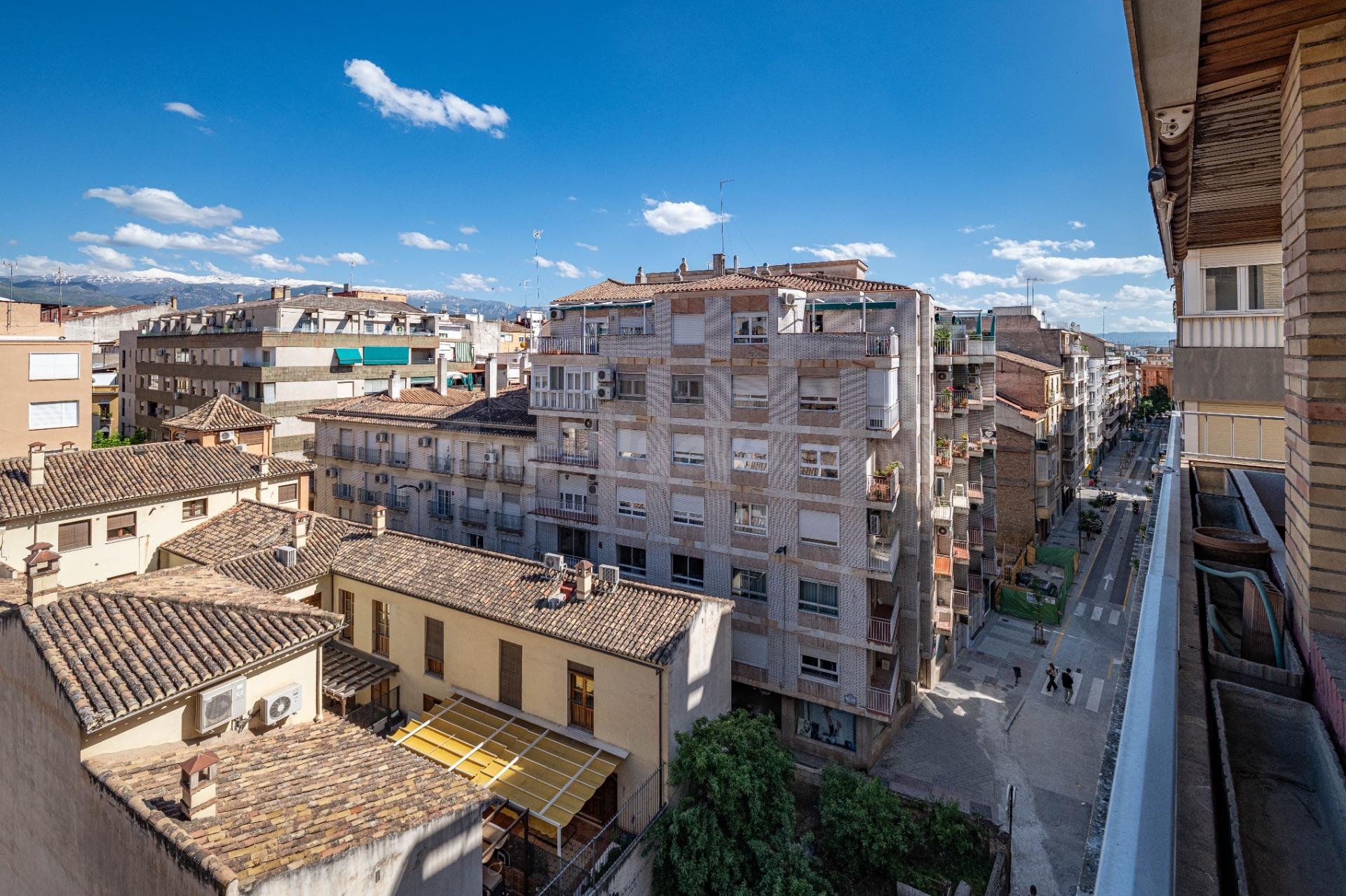Piso singular en pleno centro de Granada, junto a Recogidas, en quinta planta exterior, con mucha luz natural, terraza, vistas, cochera en el propio edificio y ascensor.