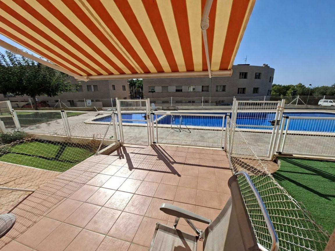 Planta baja con terraza y piscina comunitaria.
