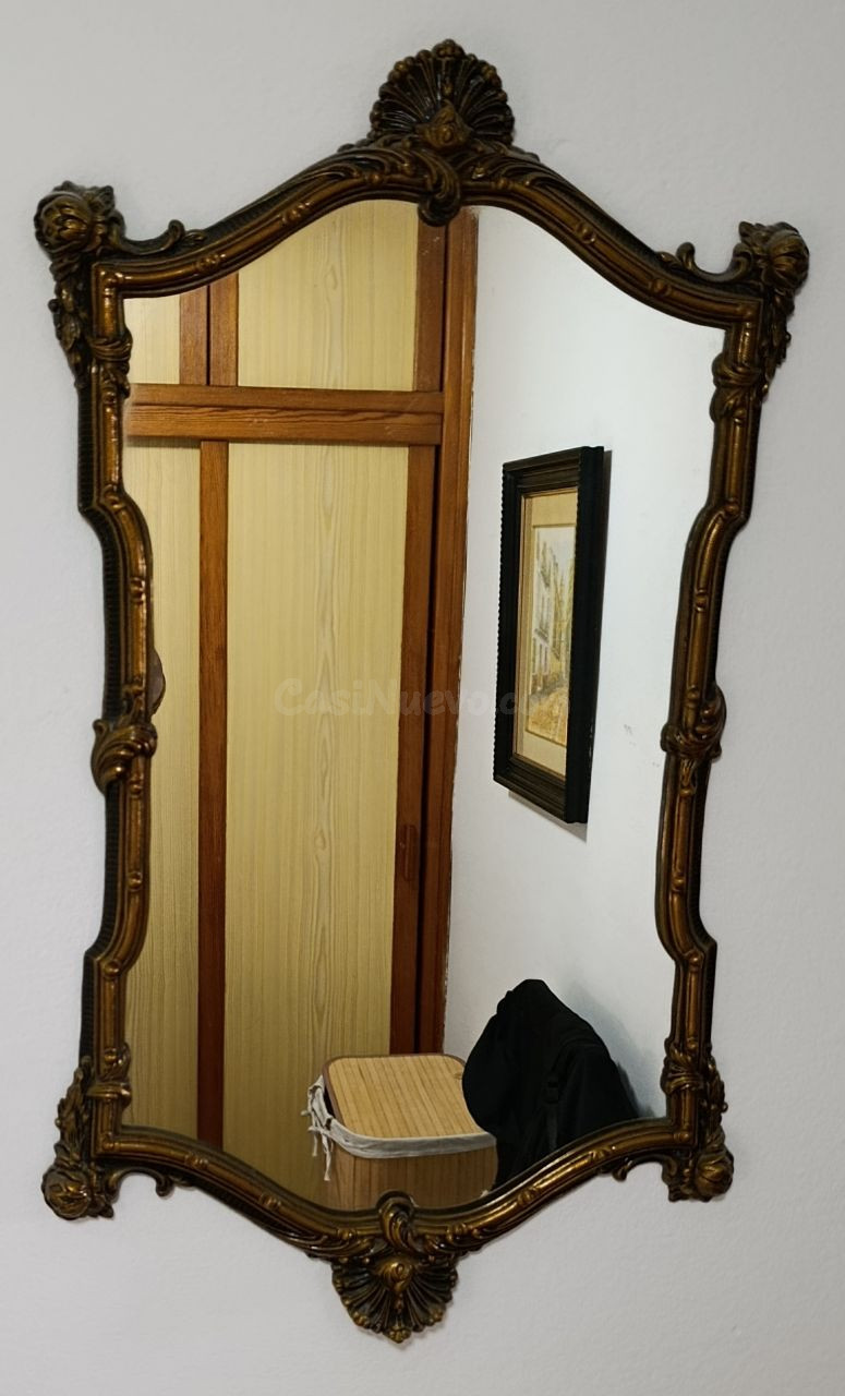 Elegante espejo con un marco detallado y acabado dorado.  - Marco con ornamentación tallada.