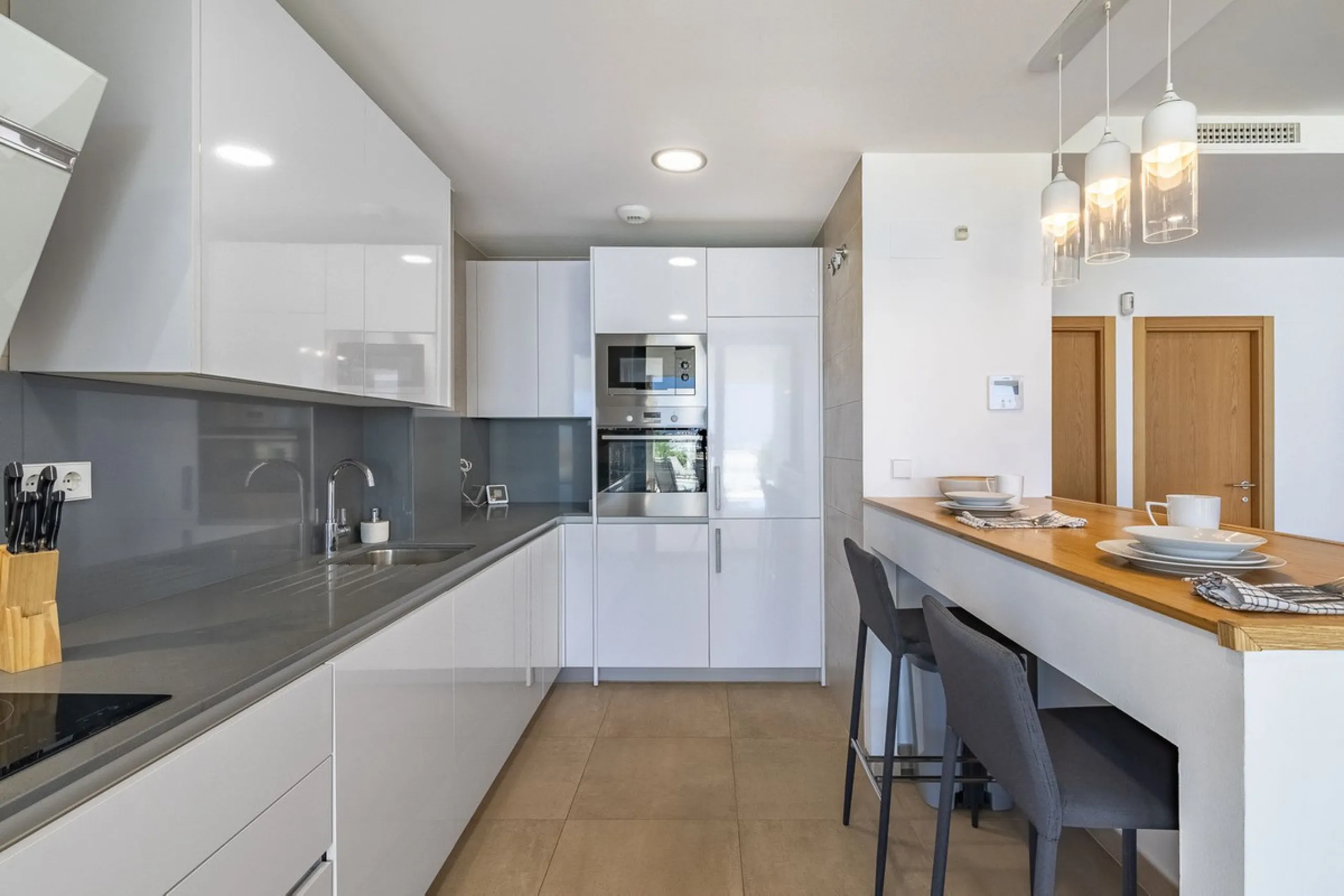This stunning two-story villa boasts four spacious bedrooms, each with fitted wardrobes, electric blinds, and individual air conditioning control. The three elegant bathrooms feature the comfort of underfloor heating.