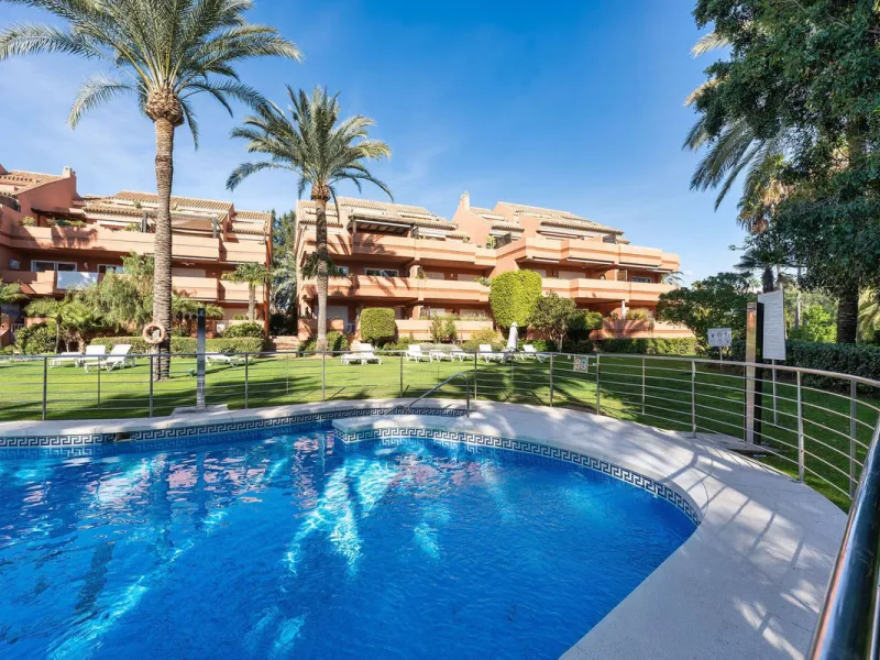 Just a short walk from the beach, this spacious two-bedroom apartment offers direct access to the beautifully maintained garden and swimming pool via a wide private terrace.
