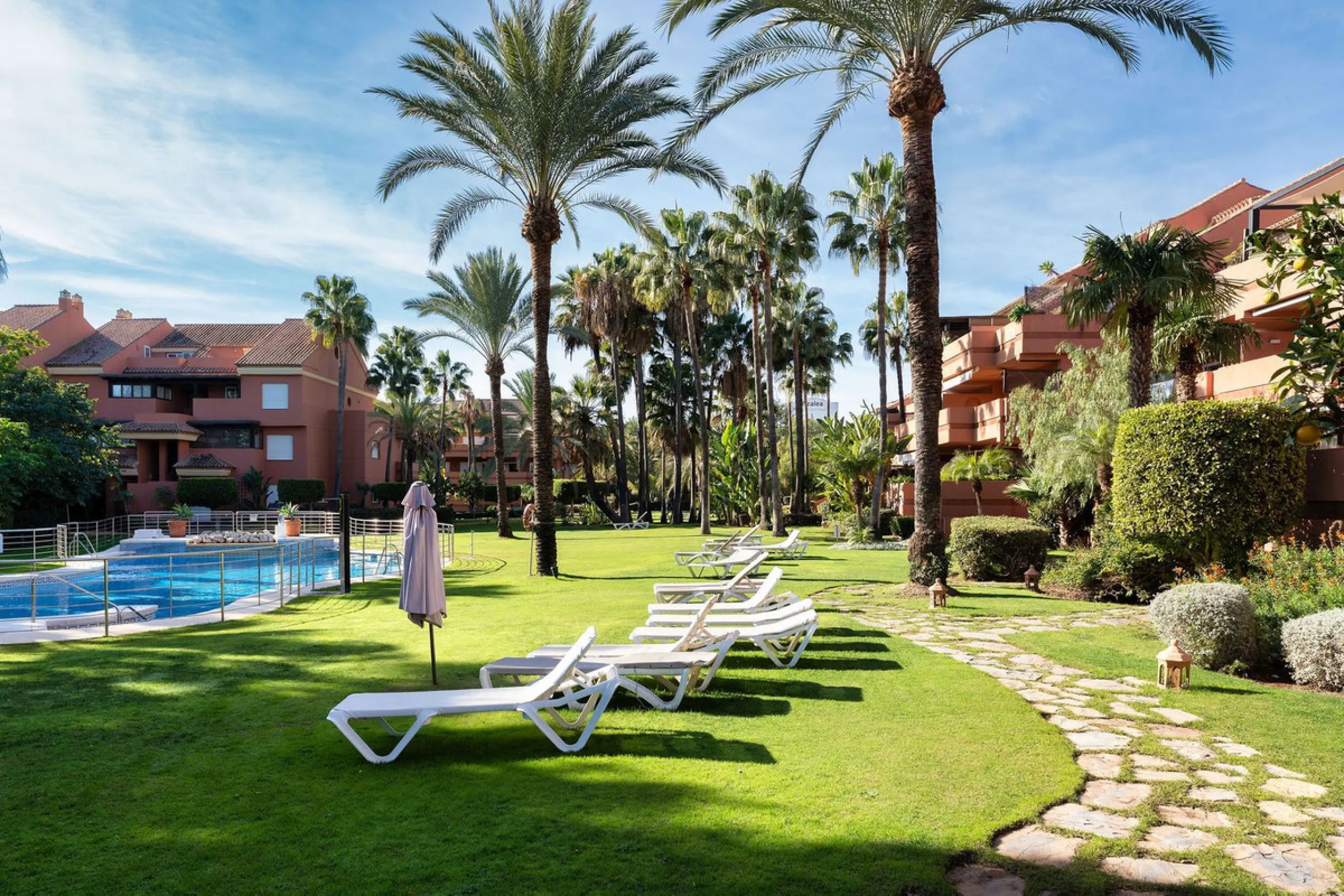 Just a short walk from the beach, this spacious two-bedroom apartment offers direct access to the beautifully maintained garden and swimming pool via a wide private terrace.