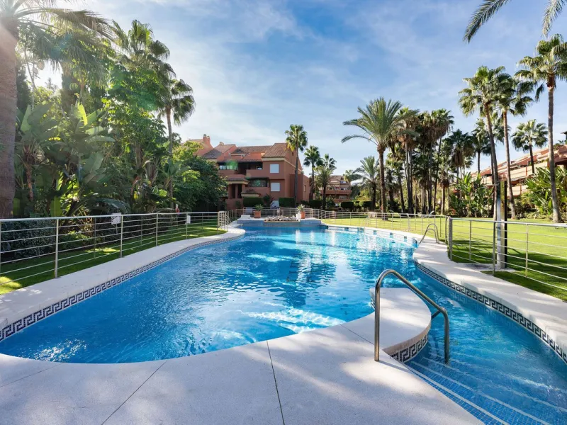 Just a short walk from the beach, this spacious two-bedroom apartment offers direct access to the beautifully maintained garden and swimming pool via a wide private terrace.