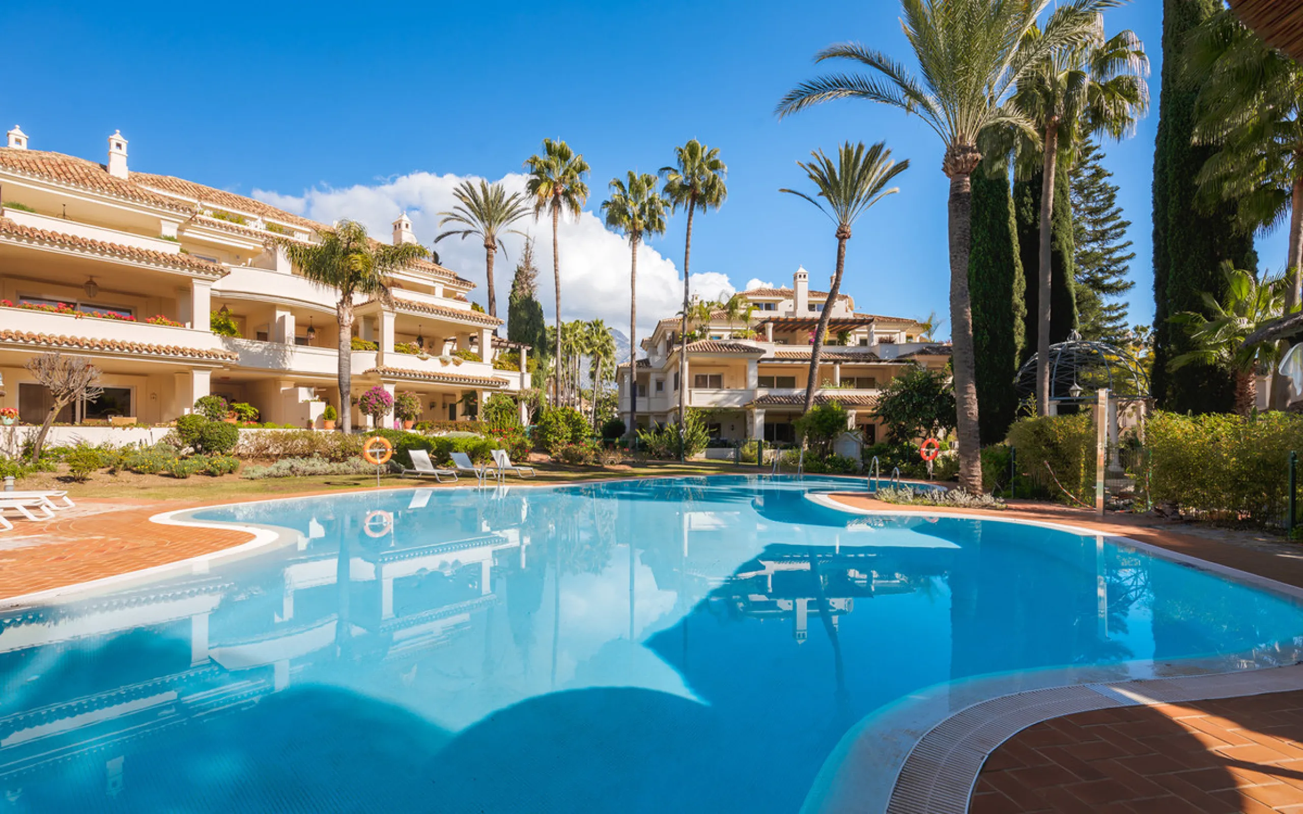 This exceptional and exquisitely designed southwest-facing duplex penthouse offers a stunning panoramic view of the award-winning gardens of Las Alamandas, in Nueva Andalucía, providing an ideal balance of sun and shade across its expansive terrace spaces