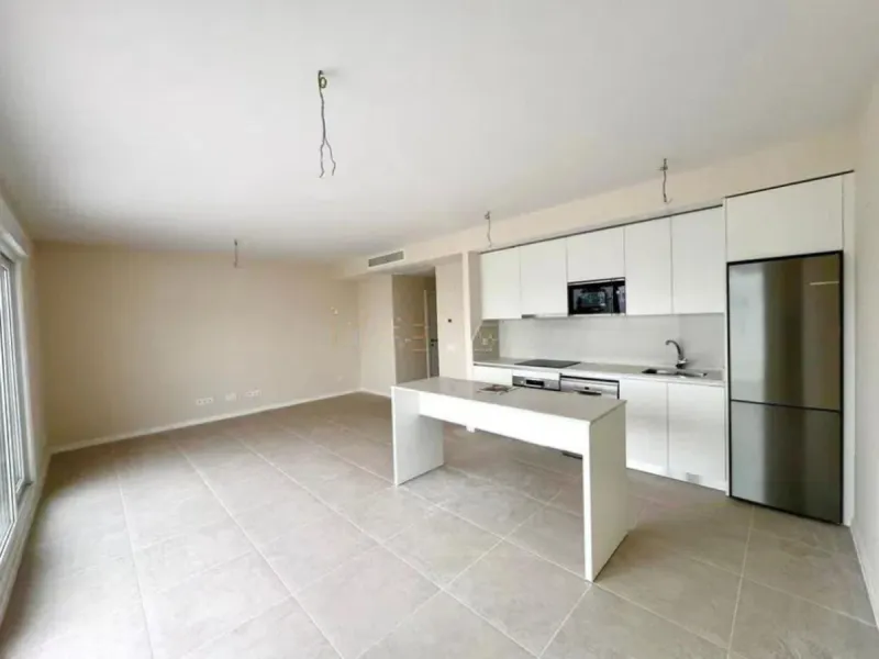 This bright, unfurnished 2-bedroom apartment pairs a practical layout with a calm outlook over the green communal landscape and a distant sea view from the terrace.