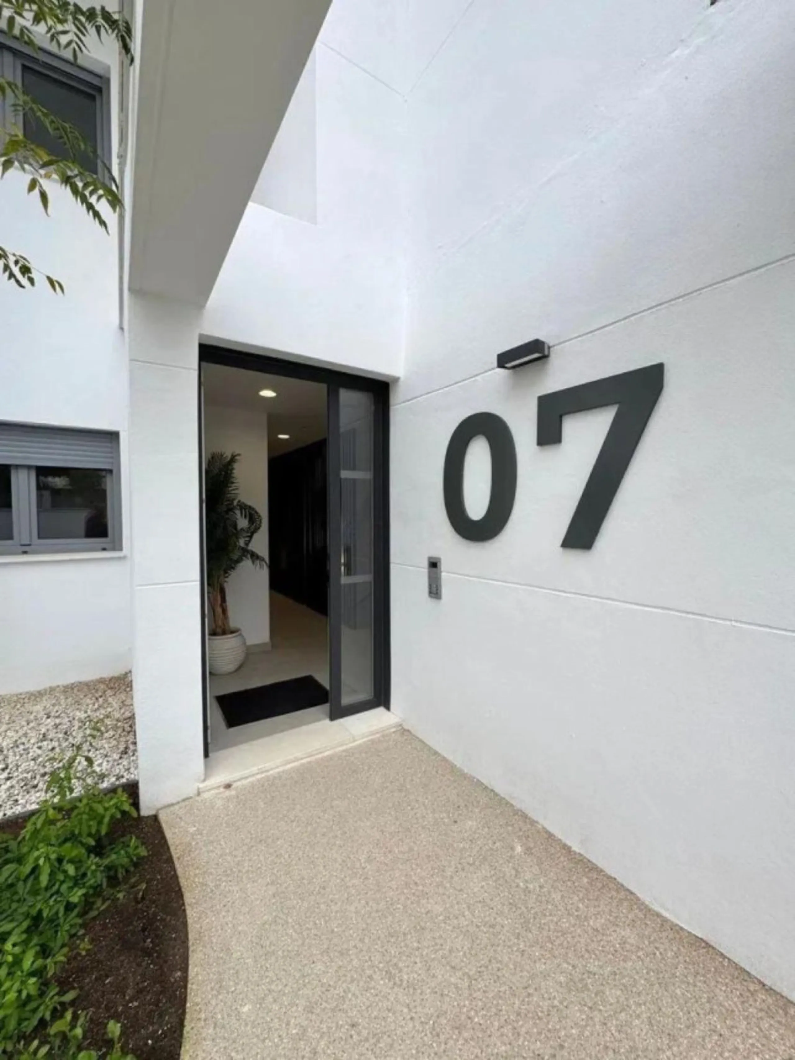 This bright, unfurnished 2-bedroom apartment pairs a practical layout with a calm outlook over the green communal landscape and a distant sea view from the terrace.