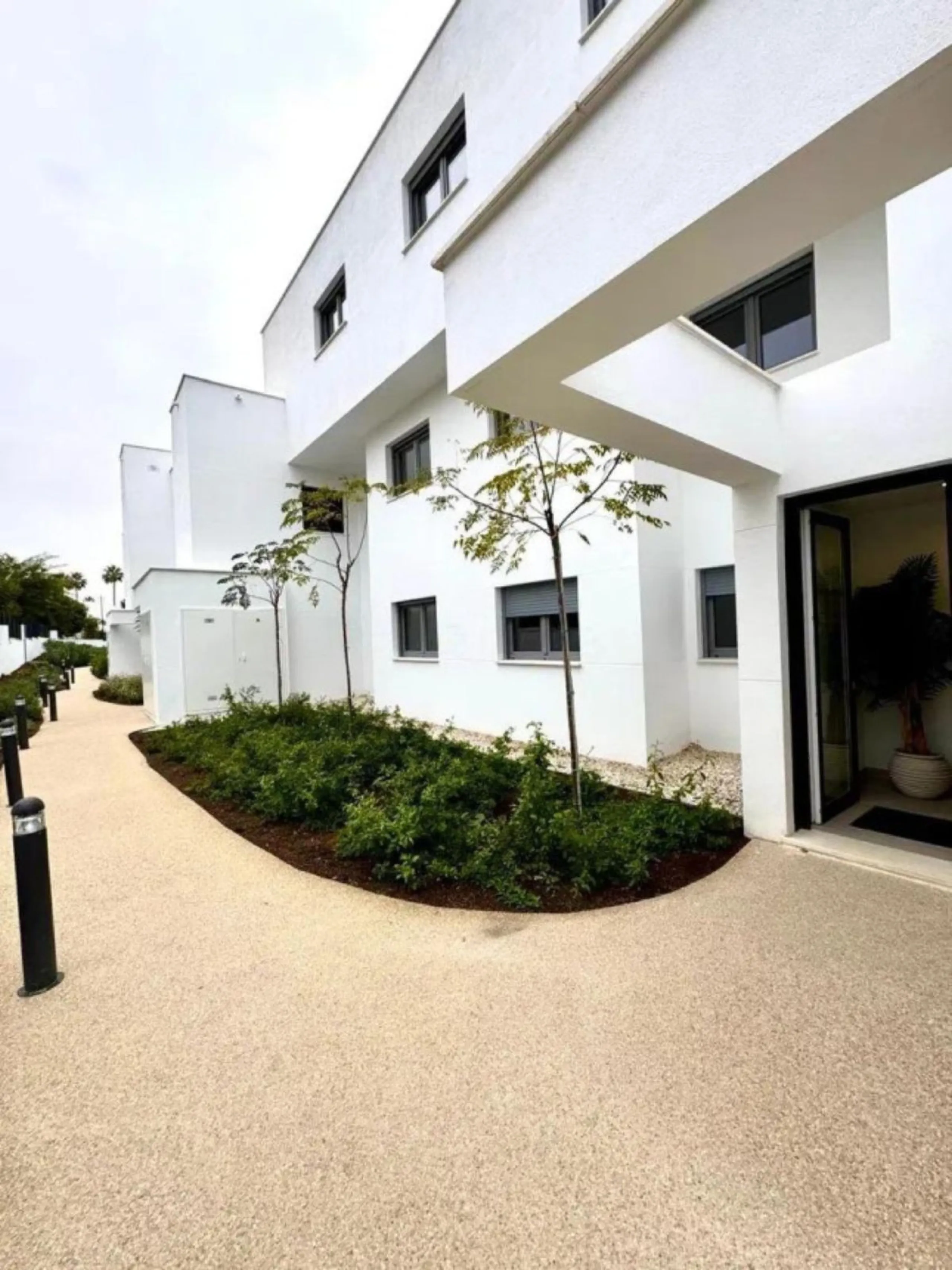 This bright, unfurnished 2-bedroom apartment pairs a practical layout with a calm outlook over the green communal landscape and a distant sea view from the terrace.