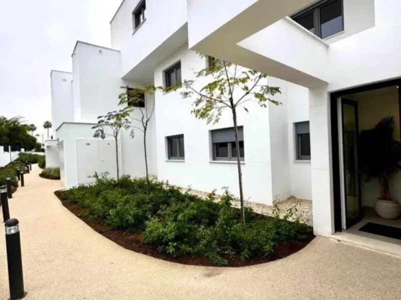 This bright, unfurnished 2-bedroom apartment pairs a practical layout with a calm outlook over the green communal landscape and a distant sea view from the terrace.