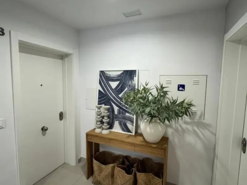 This bright, unfurnished 2-bedroom apartment pairs a practical layout with a calm outlook over the green communal landscape and a distant sea view from the terrace.