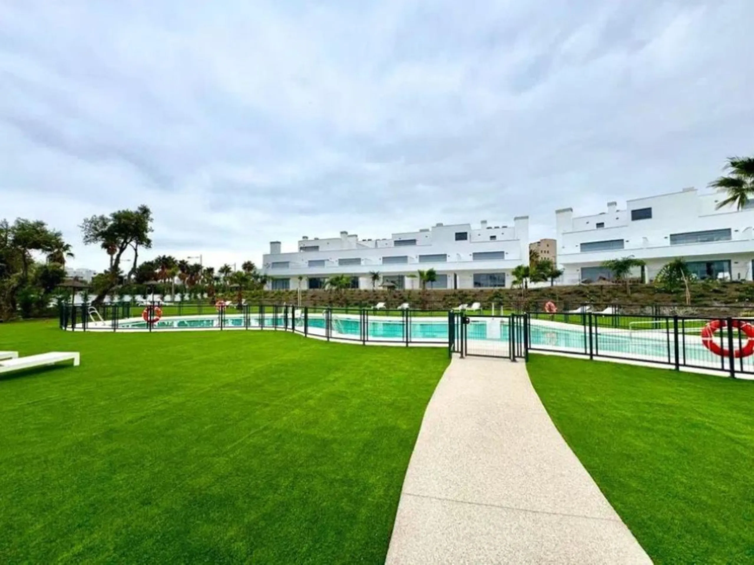 This bright, unfurnished 2-bedroom apartment pairs a practical layout with a calm outlook over the green communal landscape and a distant sea view from the terrace.