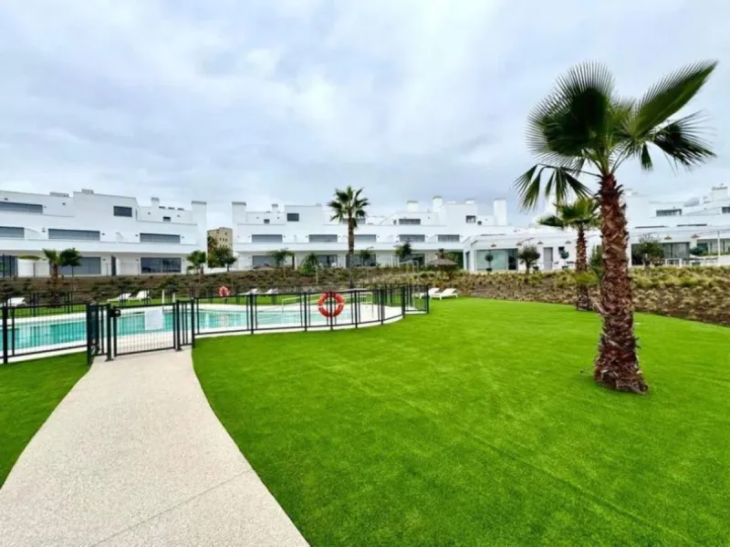 This bright, unfurnished 2-bedroom apartment pairs a practical layout with a calm outlook over the green communal landscape and a distant sea view from the terrace.