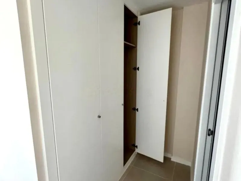 This bright, unfurnished 2-bedroom apartment pairs a practical layout with a calm outlook over the green communal landscape and a distant sea view from the terrace.