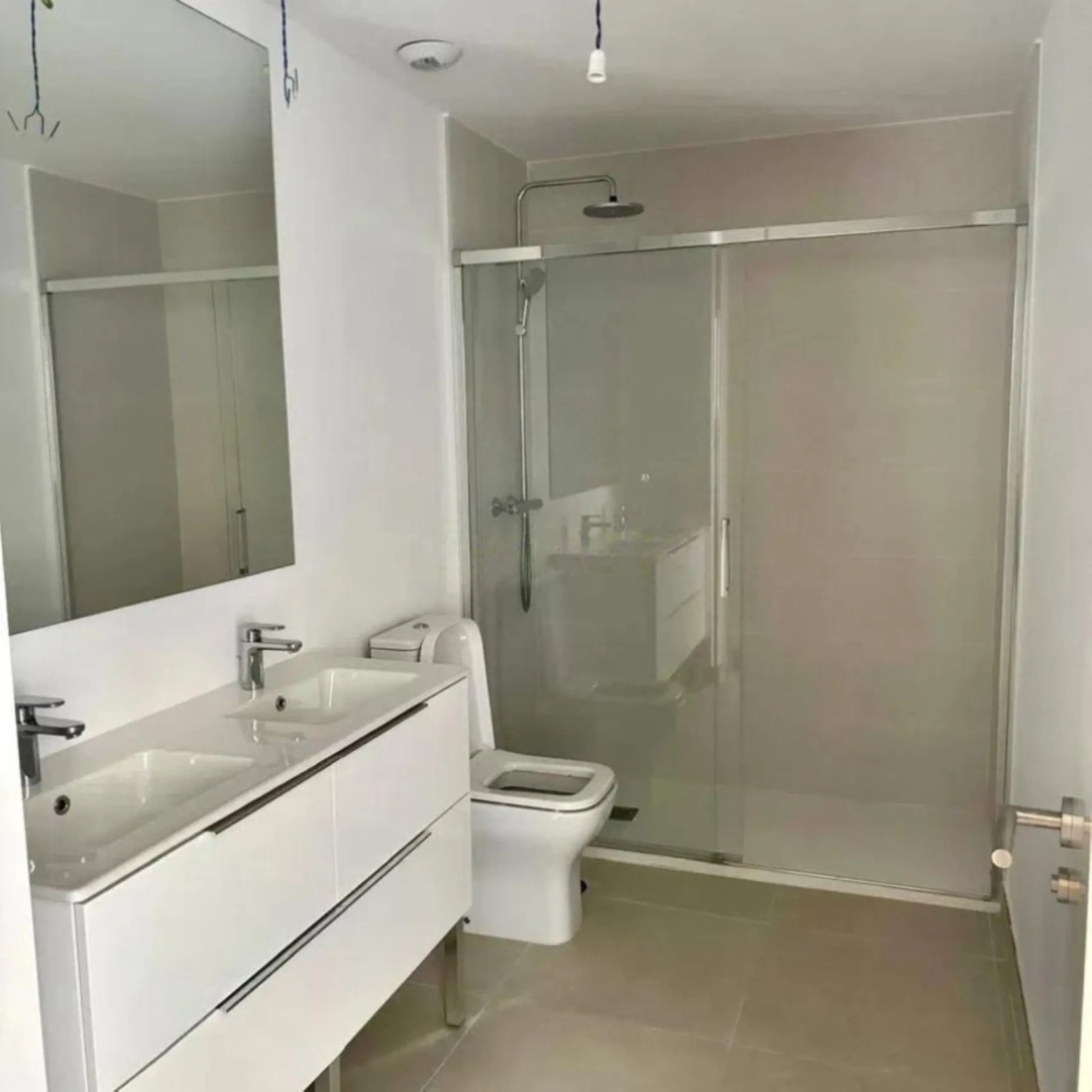 This bright, unfurnished 2-bedroom apartment pairs a practical layout with a calm outlook over the green communal landscape and a distant sea view from the terrace.