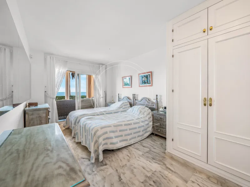 Located in a prestigious front-line beach complex just west of Estepona, this three-bedroom ground-floor apartment offers an exceptional blend of coastal comfort and relaxed Mediterranean living. With direct access to the garden and just steps from the sa