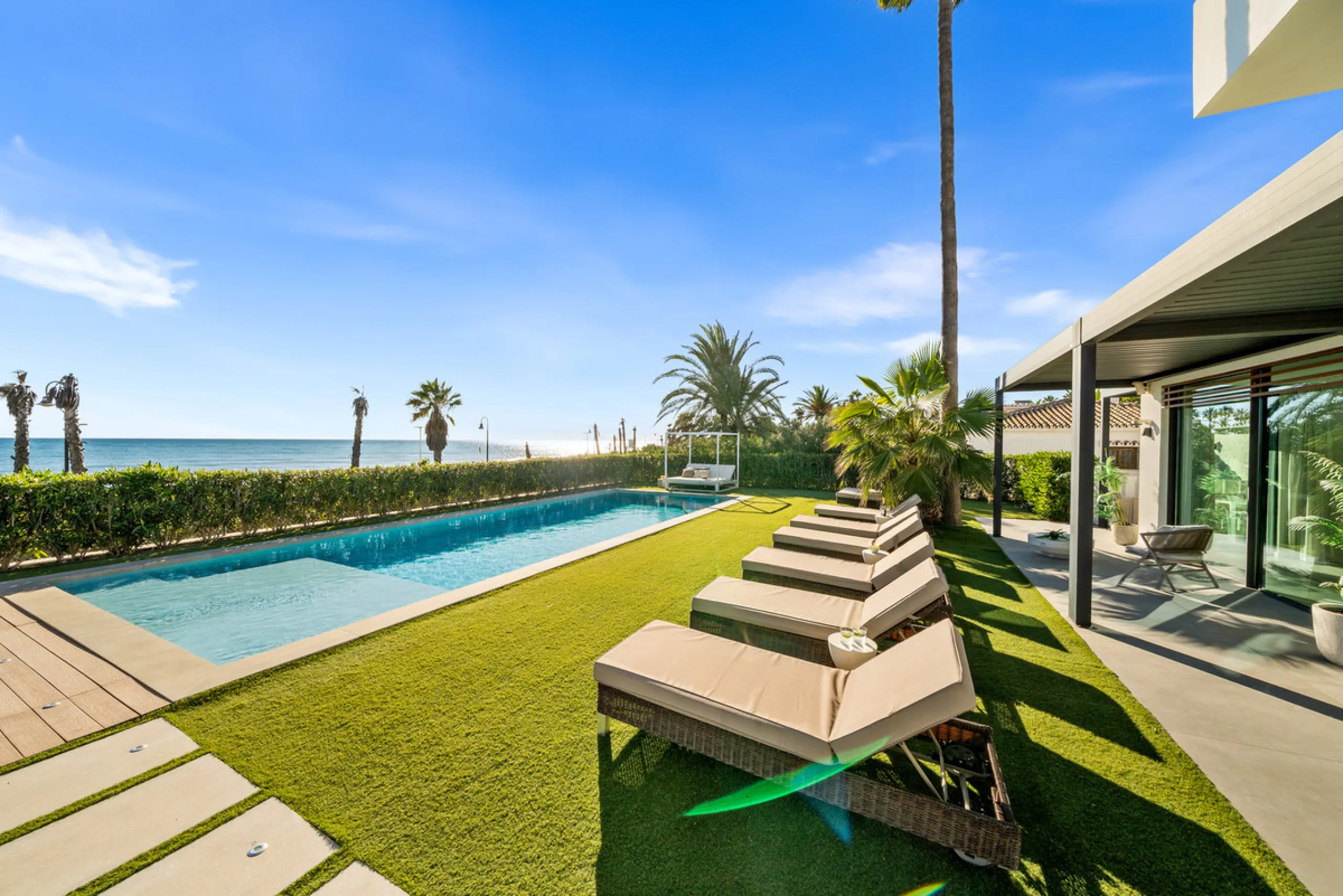 Boasting of panoramic sea views, a contemporary showpiece villa sitting in a privileged beachfront position in the New Golden Mile, surrounded by an expansive private garden with a large private swimming pool. The ideal family estate offering a dynamic ou