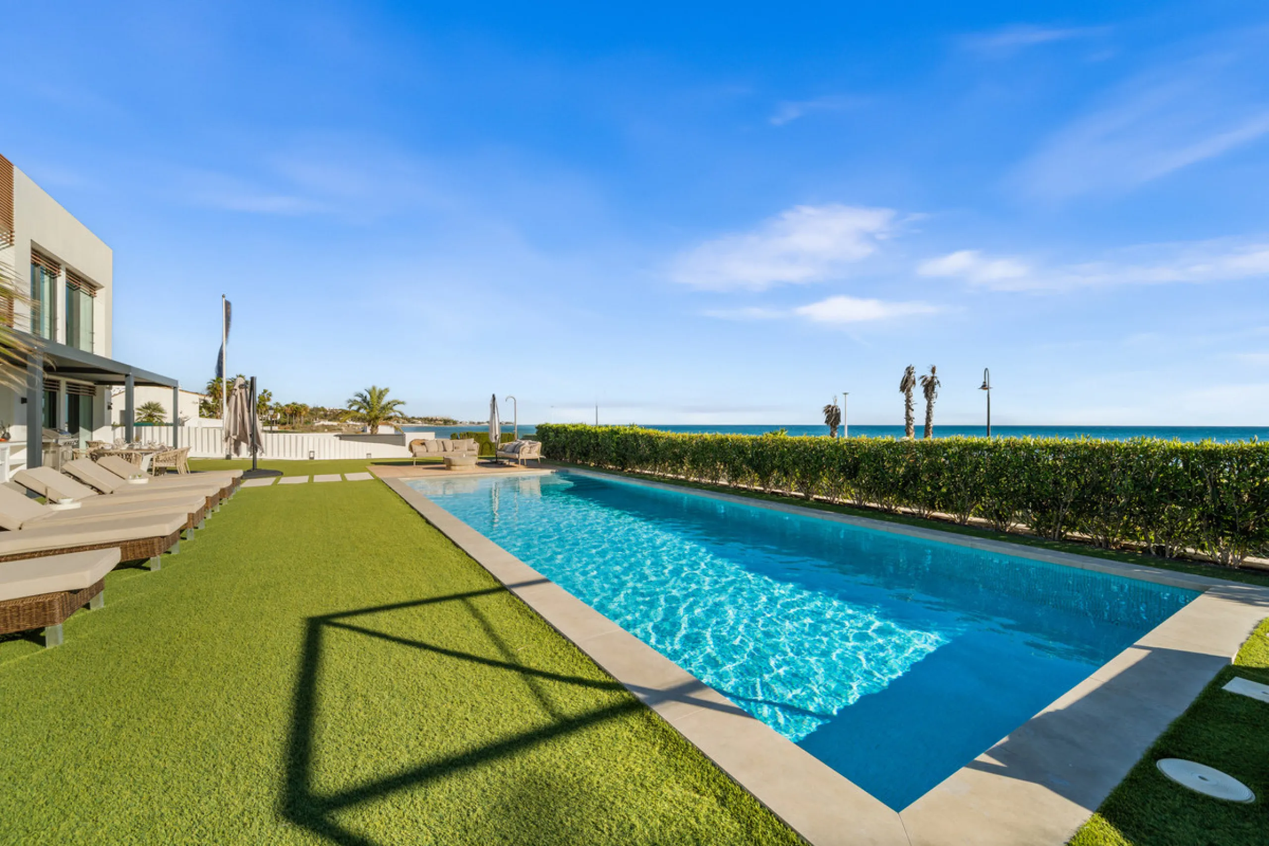 Boasting of panoramic sea views, a contemporary showpiece villa sitting in a privileged beachfront position in the New Golden Mile, surrounded by an expansive private garden with a large private swimming pool. The ideal family estate offering a dynamic ou
