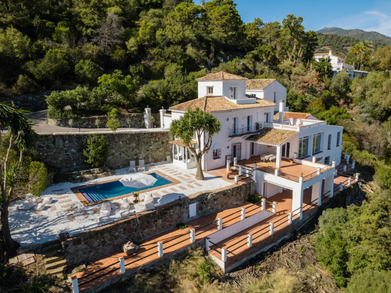 Villa in El Madroñal for sale, offering refined living within the exclusive gated community of El Madroñal 2 in Benahavís, Málaga. This six-bedroom villa with five ensuite bathrooms combines traditional Andalusian features with contemporary design. Built 