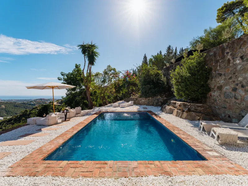 Villa in El Madroñal for sale, offering refined living within the exclusive gated community of El Madroñal 2 in Benahavís, Málaga. This six-bedroom villa with five ensuite bathrooms combines traditional Andalusian features with contemporary design. Built 