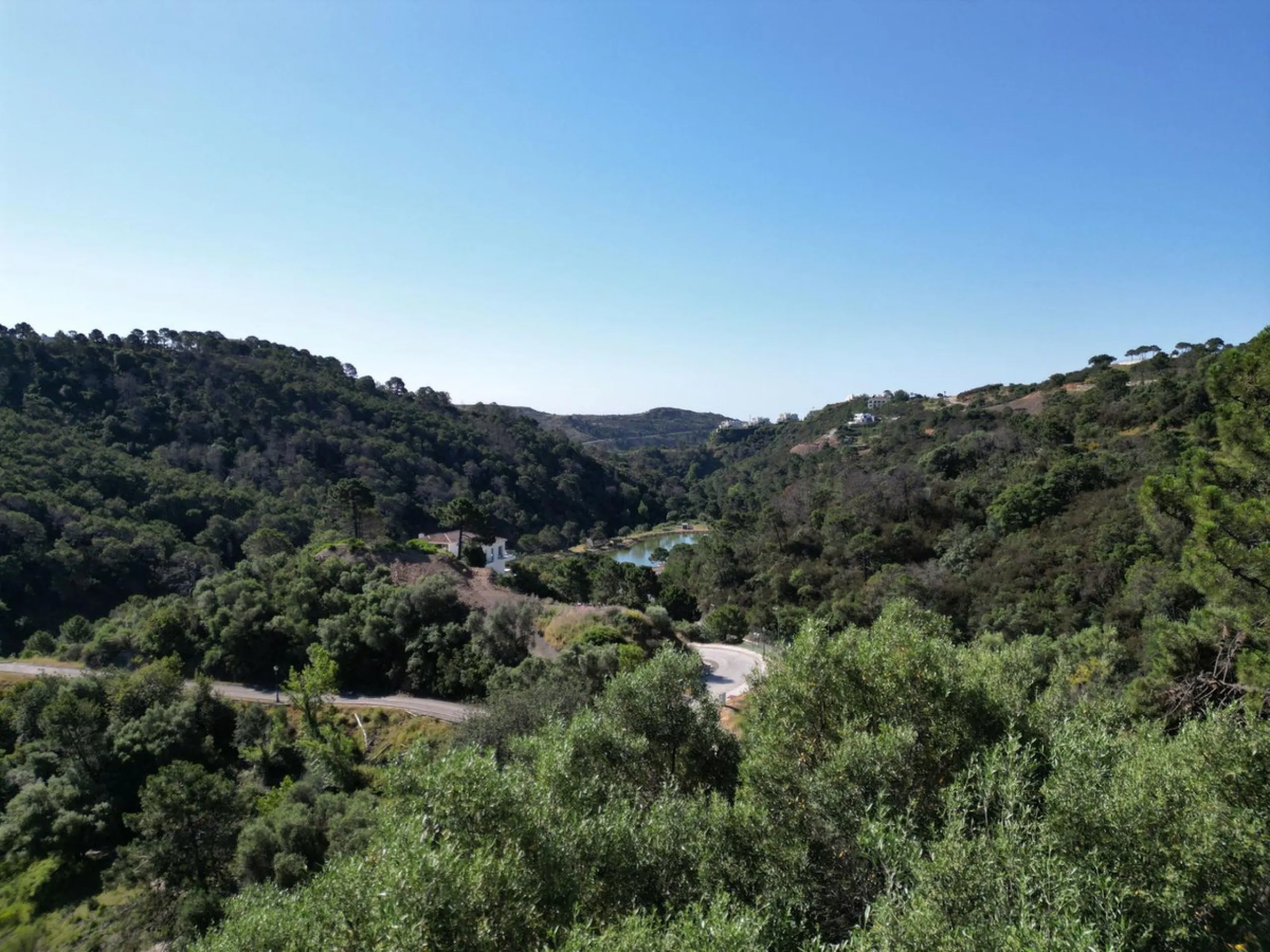 Fabulous south-facing residential plot in the exclusive country estate of Monte Mayor Resort. This large plot of €2.799m2 enjoys stunning views of the lake and surrounding landscape, and is close to the security entrance of the resort.