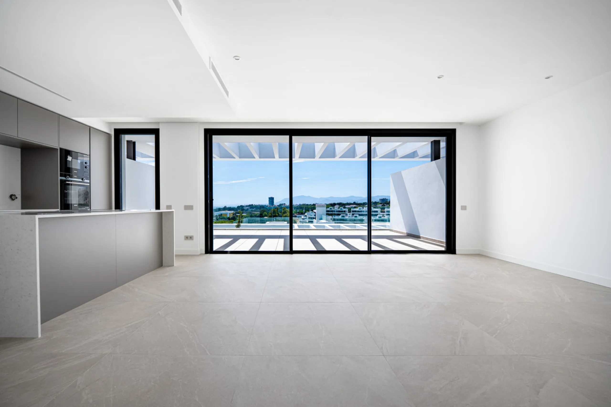 Penthouse Alma is a brand-new duplex home in a secure gated community in Marbella East. It has two ensuite bedrooms, a guest bathroom, and an open-plan living space that connects the kitchen, dining, and lounge areas. Floor-to-ceiling windows fill the hom