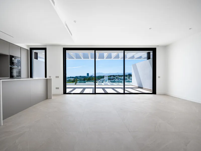 Penthouse Alma is a brand-new duplex home in a secure gated community in Marbella East. It has two ensuite bedrooms, a guest bathroom, and an open-plan living space that connects the kitchen, dining, and lounge areas. Floor-to-ceiling windows fill the hom