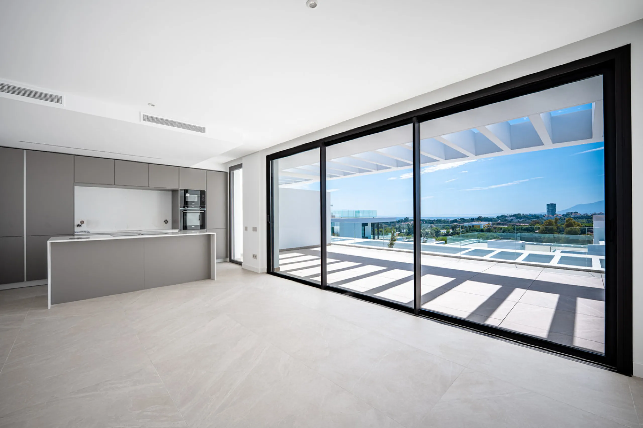 Penthouse Alma is a brand-new duplex home in a secure gated community in Marbella East. It has two ensuite bedrooms, a guest bathroom, and an open-plan living space that connects the kitchen, dining, and lounge areas. Floor-to-ceiling windows fill the hom