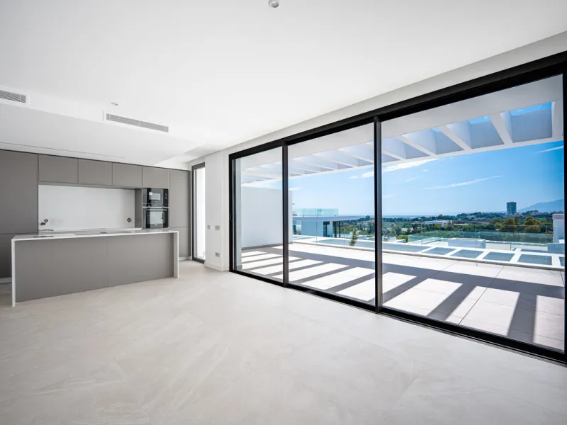 Penthouse Alma is a brand-new duplex home in a secure gated community in Marbella East. It has two ensuite bedrooms, a guest bathroom, and an open-plan living space that connects the kitchen, dining, and lounge areas. Floor-to-ceiling windows fill the hom