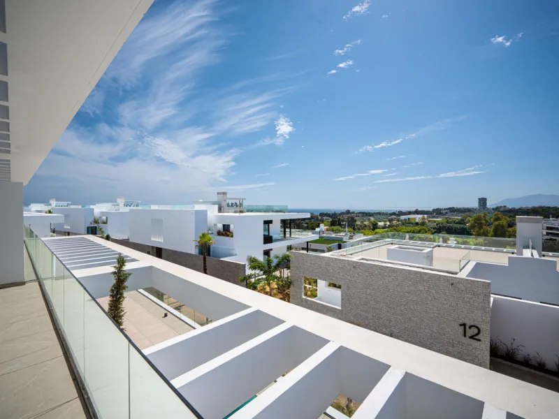 Penthouse Alma is a brand-new duplex home in a secure gated community in Marbella East. It has two ensuite bedrooms, a guest bathroom, and an open-plan living space that connects the kitchen, dining, and lounge areas. Floor-to-ceiling windows fill the hom