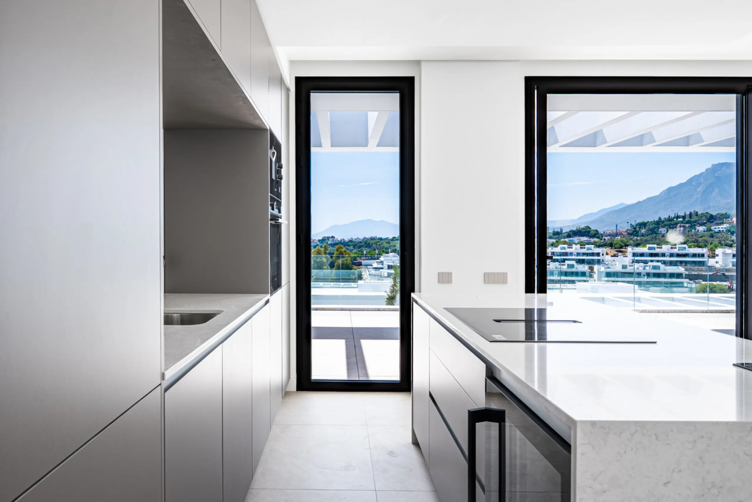 Penthouse Alma is a brand-new duplex home in a secure gated community in Marbella East. It has two ensuite bedrooms, a guest bathroom, and an open-plan living space that connects the kitchen, dining, and lounge areas. Floor-to-ceiling windows fill the hom