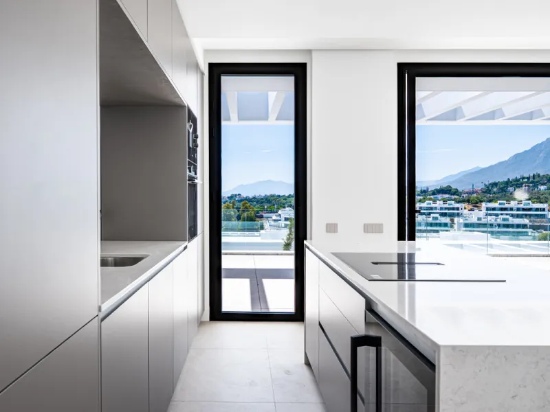 Penthouse Alma is a brand-new duplex home in a secure gated community in Marbella East. It has two ensuite bedrooms, a guest bathroom, and an open-plan living space that connects the kitchen, dining, and lounge areas. Floor-to-ceiling windows fill the hom