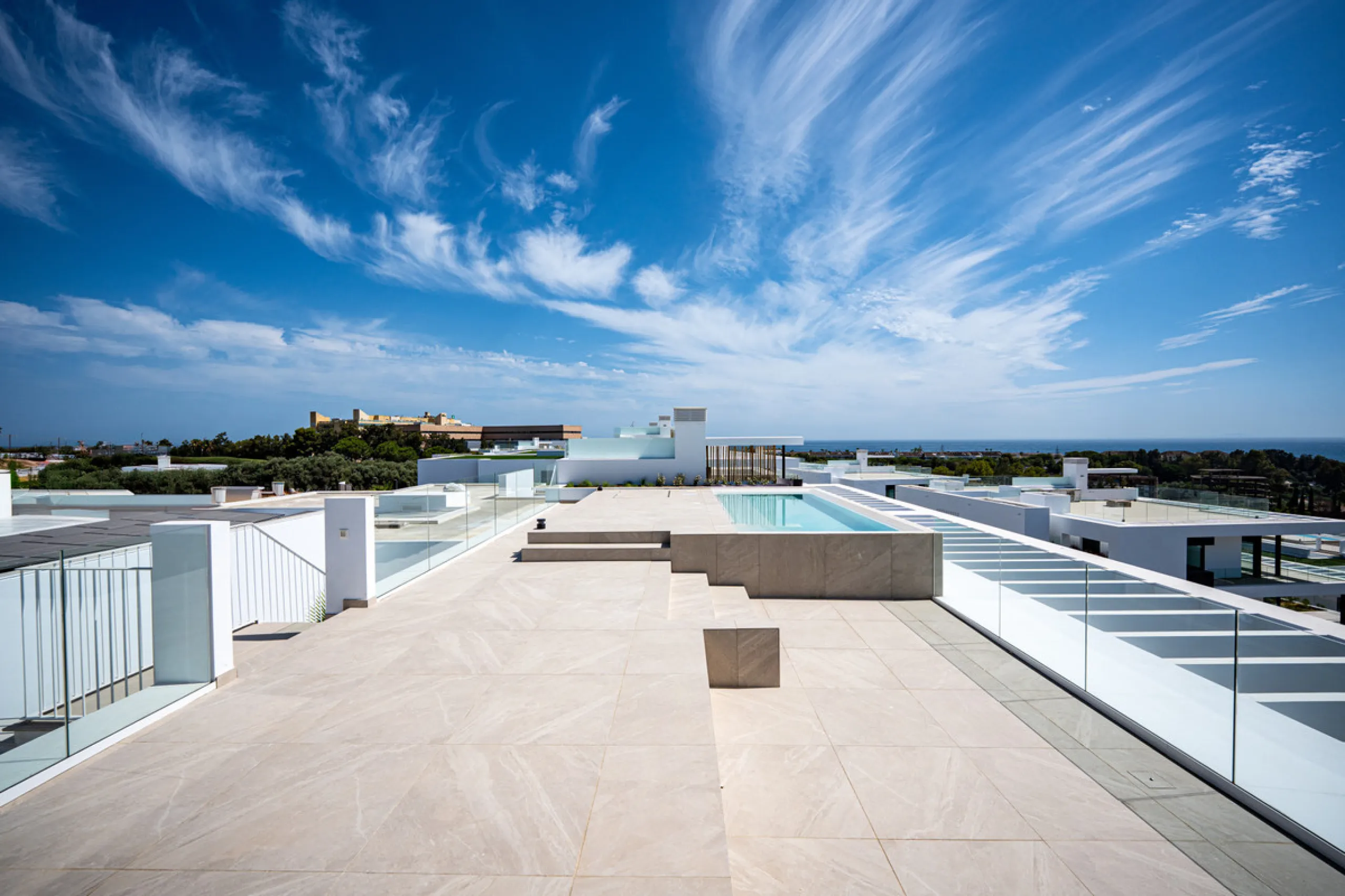 Penthouse Alma is a brand-new duplex home in a secure gated community in Marbella East. It has two ensuite bedrooms, a guest bathroom, and an open-plan living space that connects the kitchen, dining, and lounge areas. Floor-to-ceiling windows fill the hom
