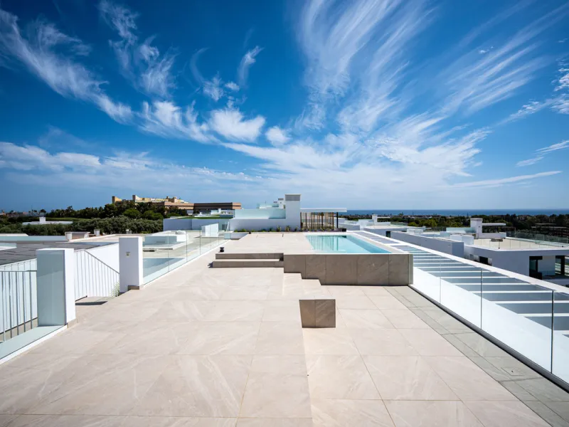 Penthouse Alma is a brand-new duplex home in a secure gated community in Marbella East. It has two ensuite bedrooms, a guest bathroom, and an open-plan living space that connects the kitchen, dining, and lounge areas. Floor-to-ceiling windows fill the hom