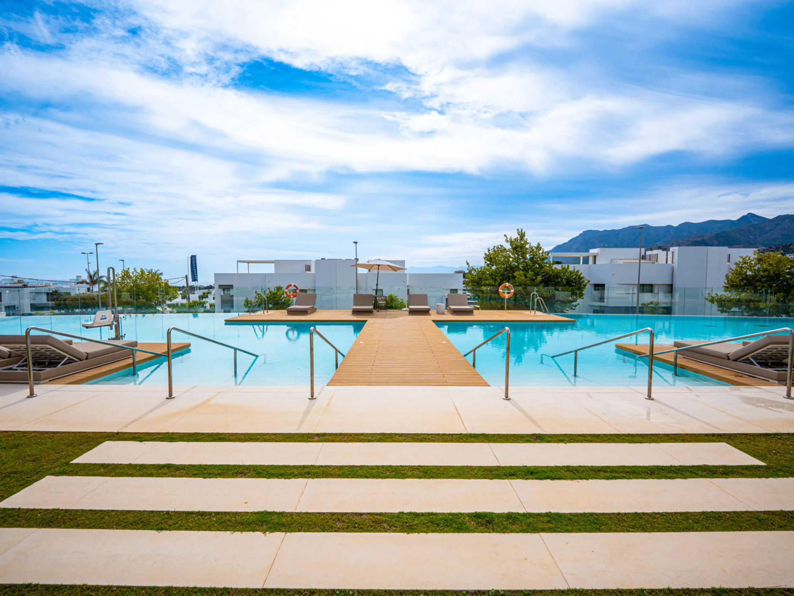 Penthouse Alma is a brand-new duplex home in a secure gated community in Marbella East. It has two ensuite bedrooms, a guest bathroom, and an open-plan living space that connects the kitchen, dining, and lounge areas. Floor-to-ceiling windows fill the hom