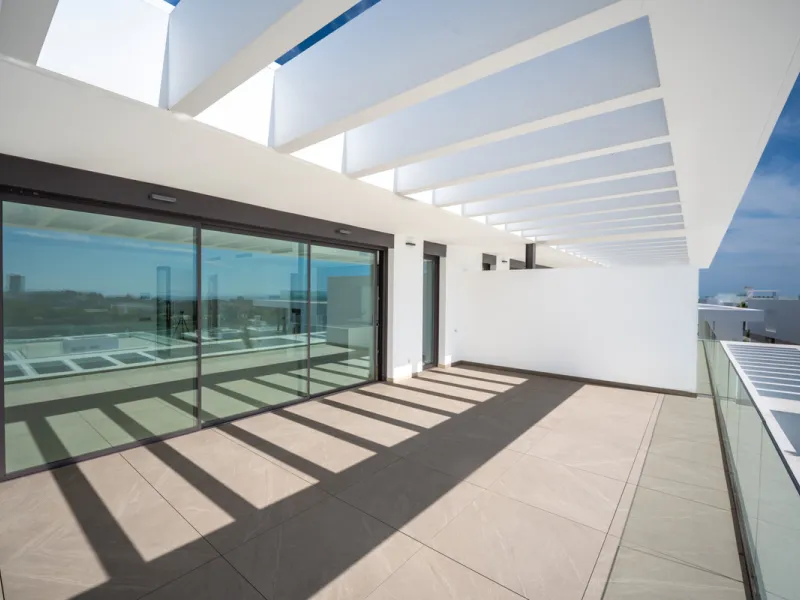 Penthouse Alma is a brand-new duplex home in a secure gated community in Marbella East. It has two ensuite bedrooms, a guest bathroom, and an open-plan living space that connects the kitchen, dining, and lounge areas. Floor-to-ceiling windows fill the hom