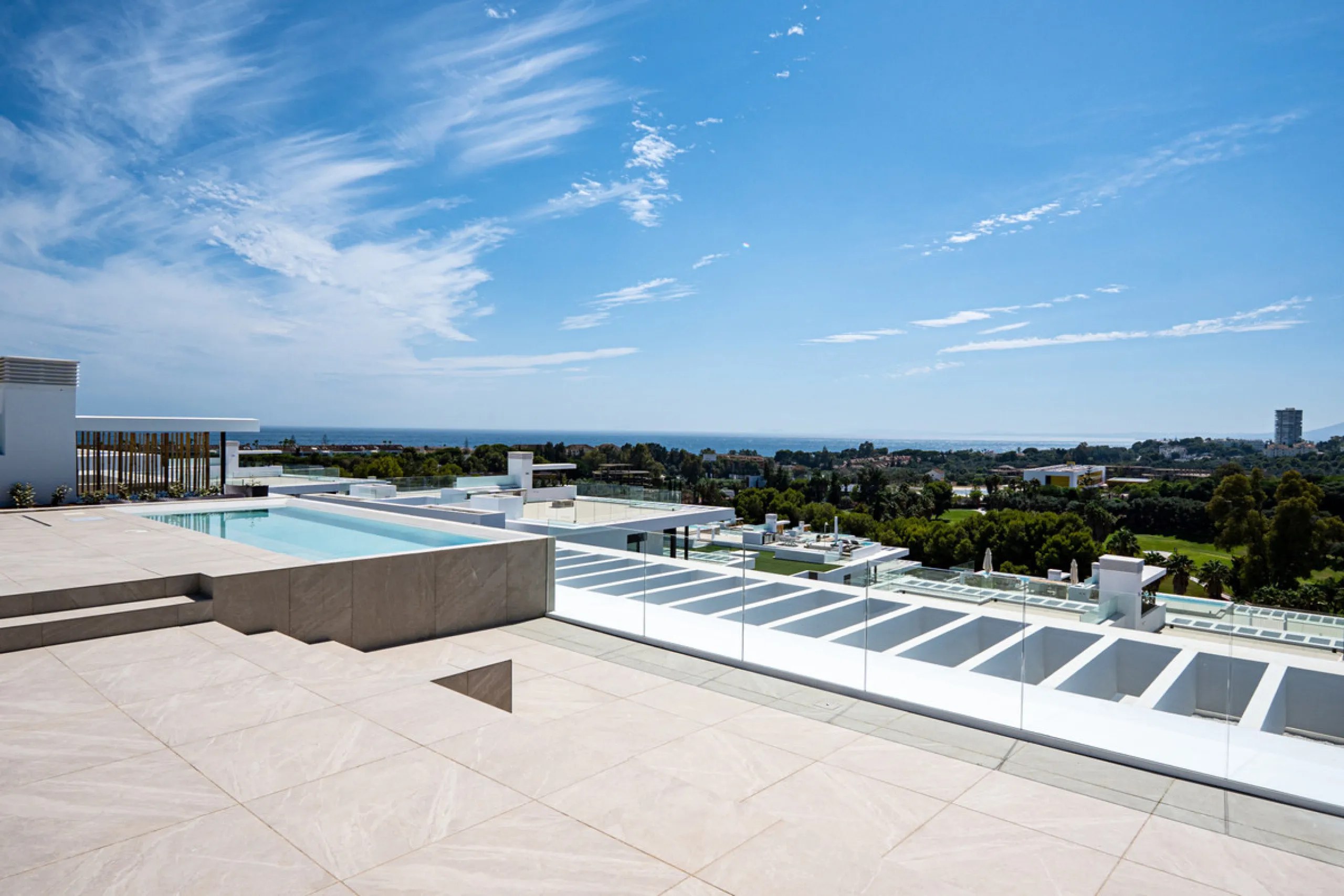 Penthouse Alma is a brand-new duplex home in a secure gated community in Marbella East. It has two ensuite bedrooms, a guest bathroom, and an open-plan living space that connects the kitchen, dining, and lounge areas. Floor-to-ceiling windows fill the hom