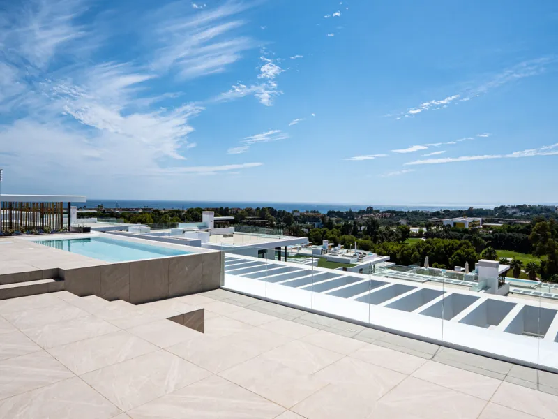 Penthouse Alma is a brand-new duplex home in a secure gated community in Marbella East. It has two ensuite bedrooms, a guest bathroom, and an open-plan living space that connects the kitchen, dining, and lounge areas. Floor-to-ceiling windows fill the hom