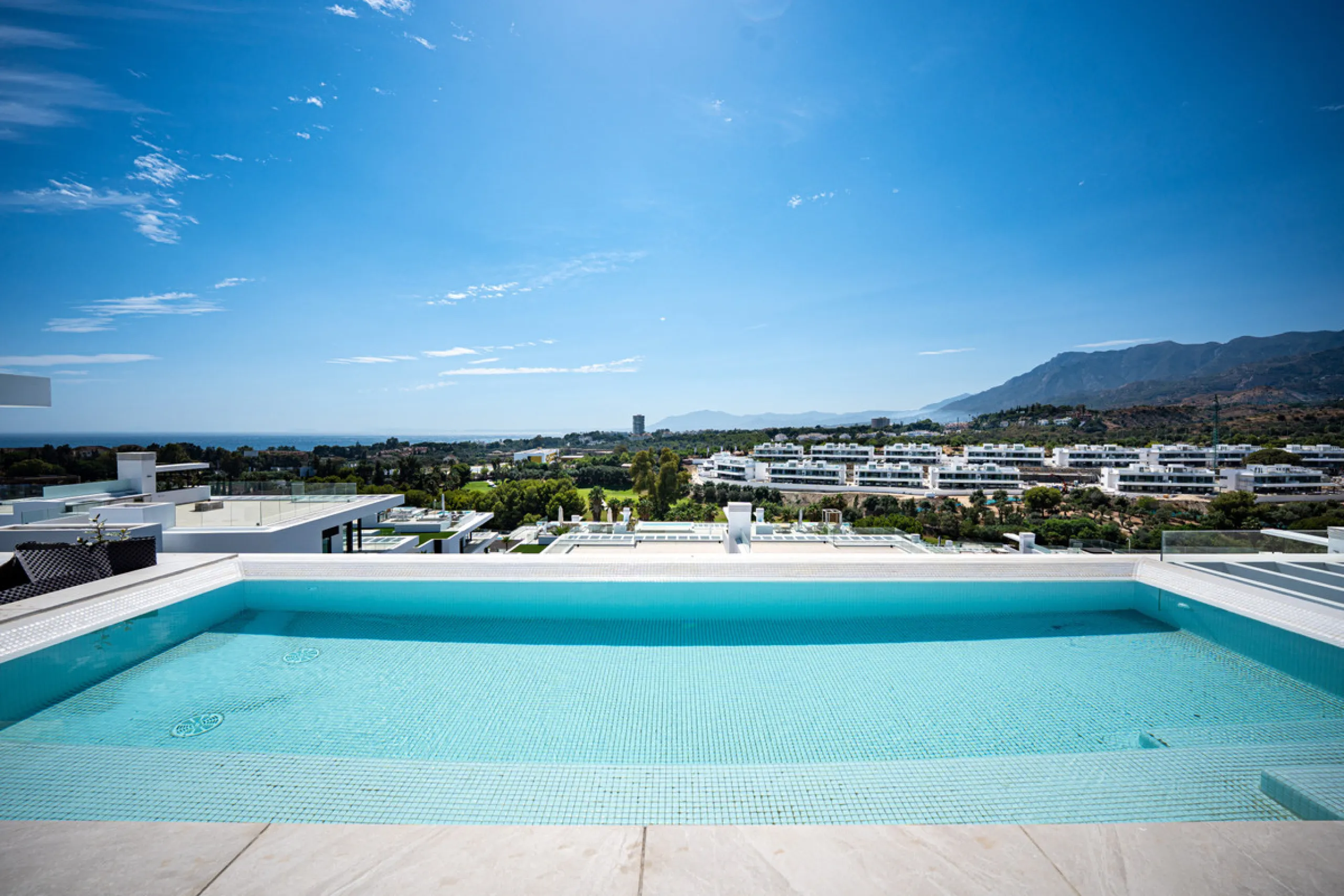Penthouse Alma is a brand-new duplex home in a secure gated community in Marbella East. It has two ensuite bedrooms, a guest bathroom, and an open-plan living space that connects the kitchen, dining, and lounge areas. Floor-to-ceiling windows fill the hom
