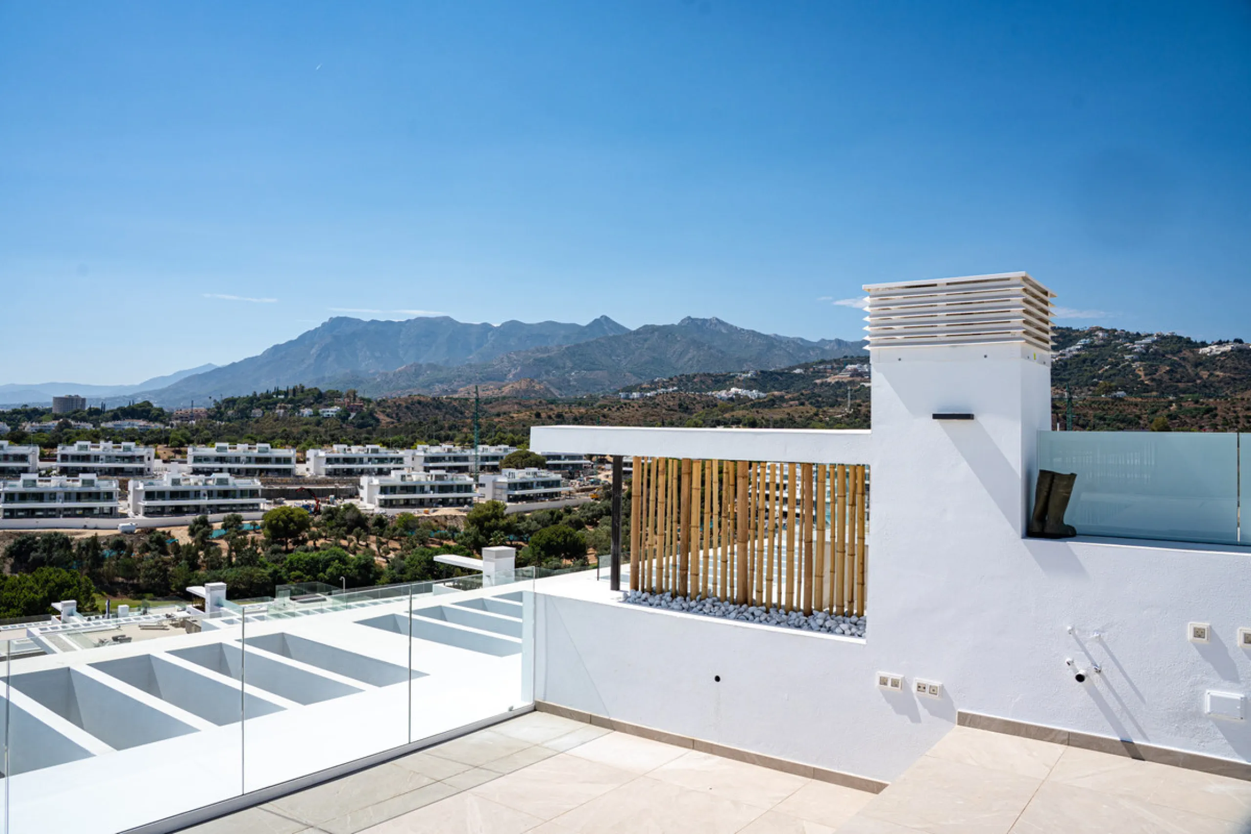 Penthouse Alma is a brand-new duplex home in a secure gated community in Marbella East. It has two ensuite bedrooms, a guest bathroom, and an open-plan living space that connects the kitchen, dining, and lounge areas. Floor-to-ceiling windows fill the hom