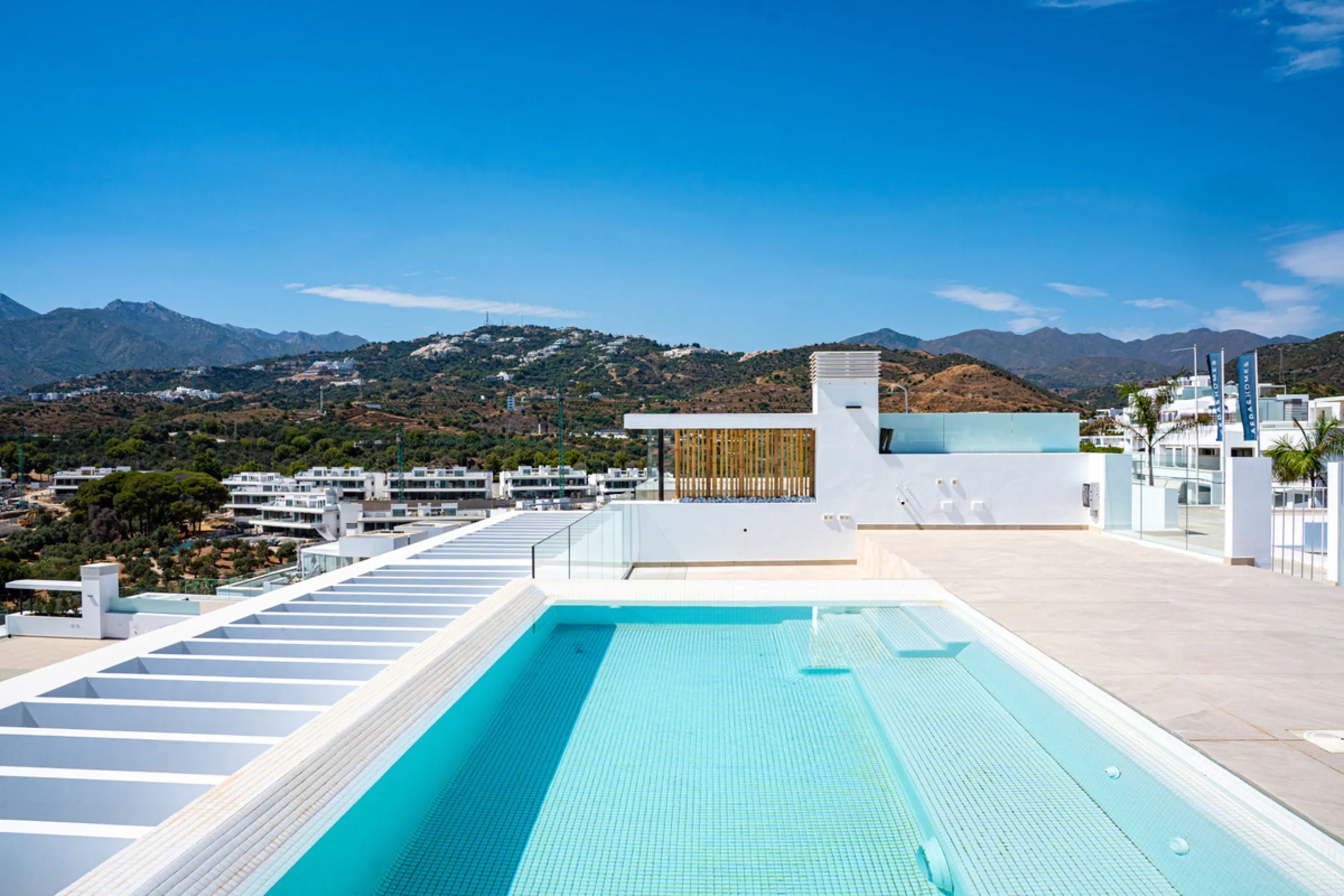 Penthouse Alma is a brand-new duplex home in a secure gated community in Marbella East. It has two ensuite bedrooms, a guest bathroom, and an open-plan living space that connects the kitchen, dining, and lounge areas. Floor-to-ceiling windows fill the hom