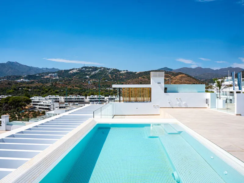 Penthouse Alma is a brand-new duplex home in a secure gated community in Marbella East. It has two ensuite bedrooms, a guest bathroom, and an open-plan living space that connects the kitchen, dining, and lounge areas. Floor-to-ceiling windows fill the hom