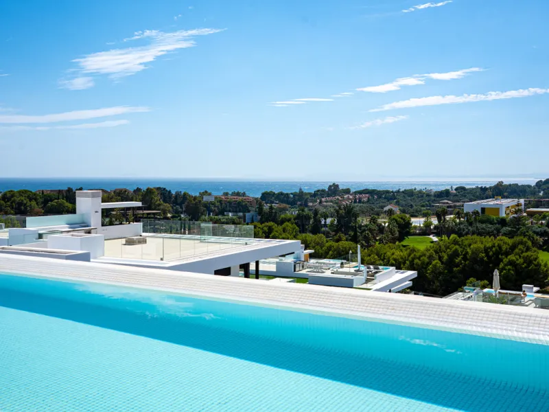 Penthouse Alma is a brand-new duplex home in a secure gated community in Marbella East. It has two ensuite bedrooms, a guest bathroom, and an open-plan living space that connects the kitchen, dining, and lounge areas. Floor-to-ceiling windows fill the hom